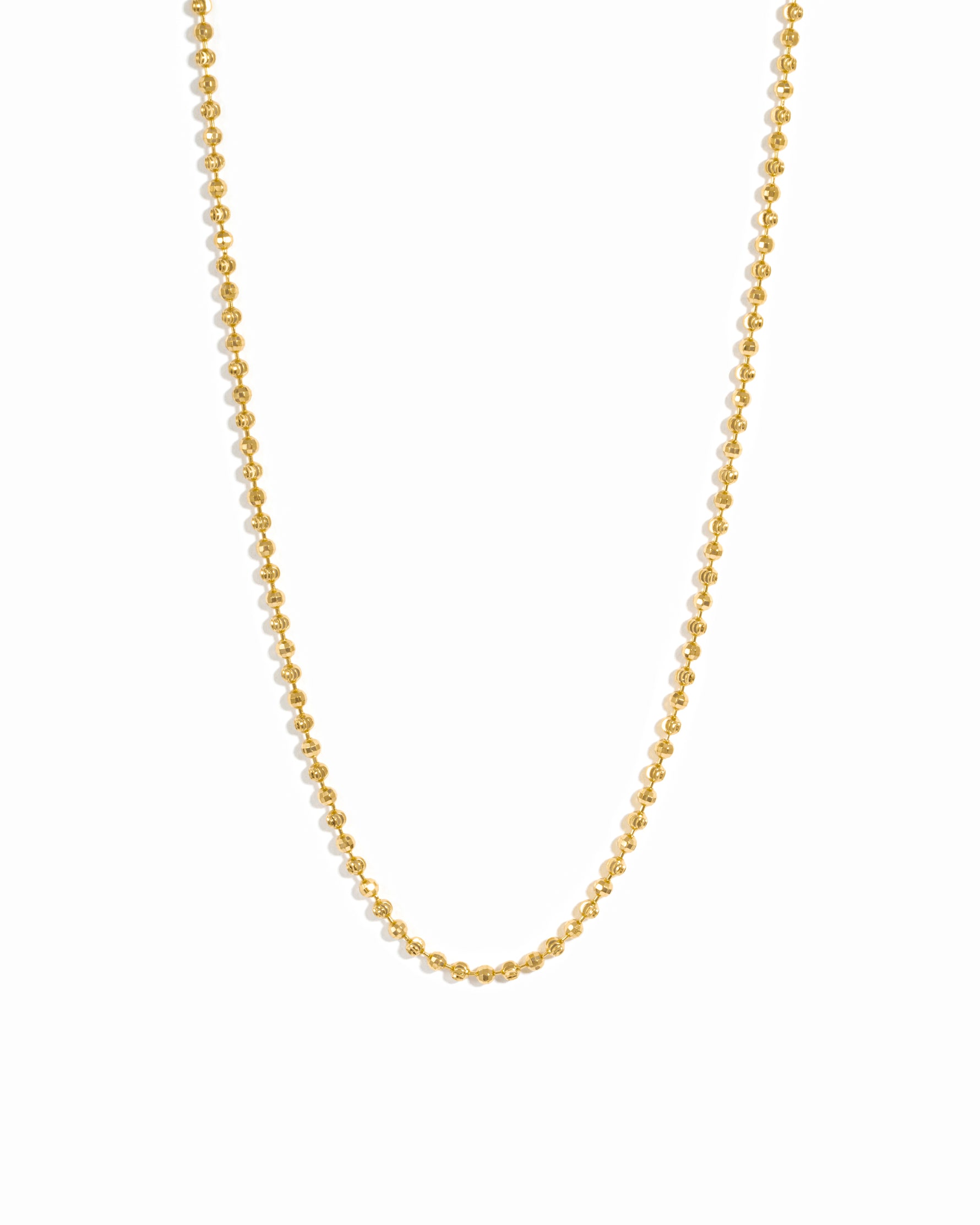 Gold beaded necklace on white background