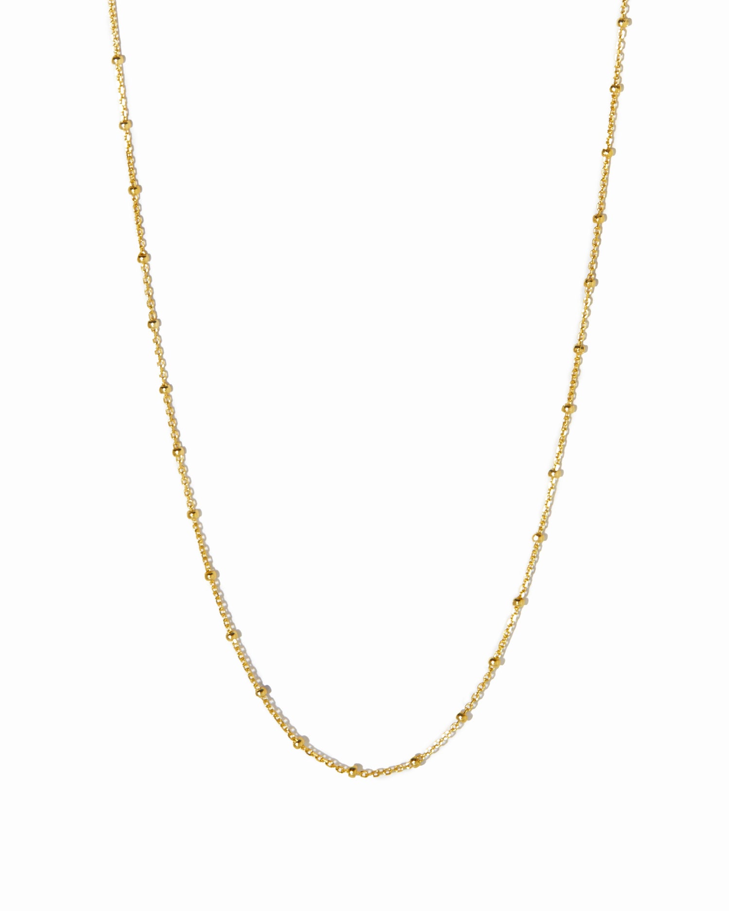 Gold chain beaded necklace on a white background