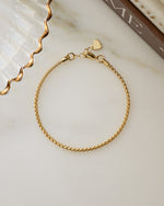 Gold adjustable bracelet on marble background