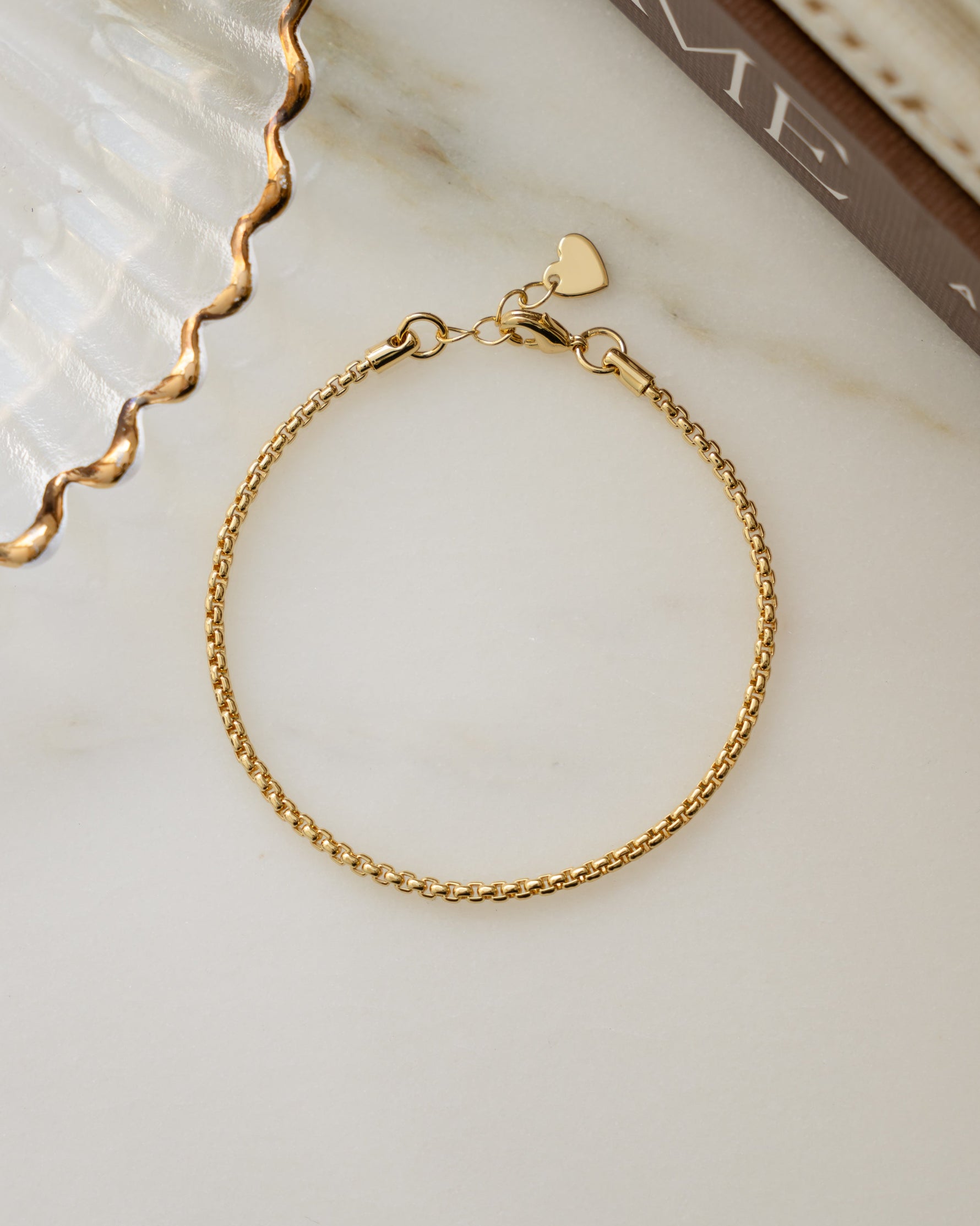 Gold adjustable bracelet on marble background