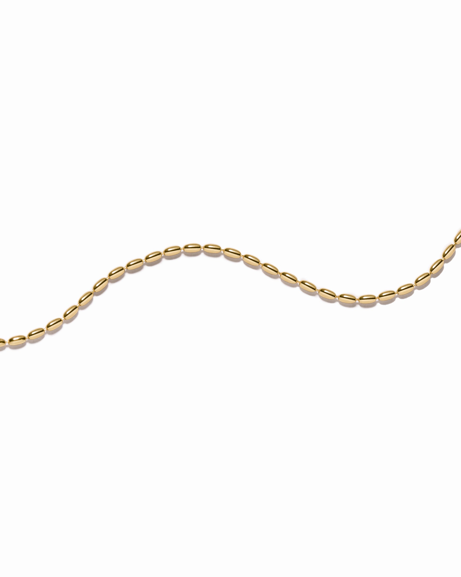 Gold chain stackable bracelet on a white background