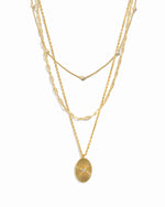 Gold layered chain necklaces with a paperclip chain and beaded necklace design, and a gold central pendant necklace on a white background