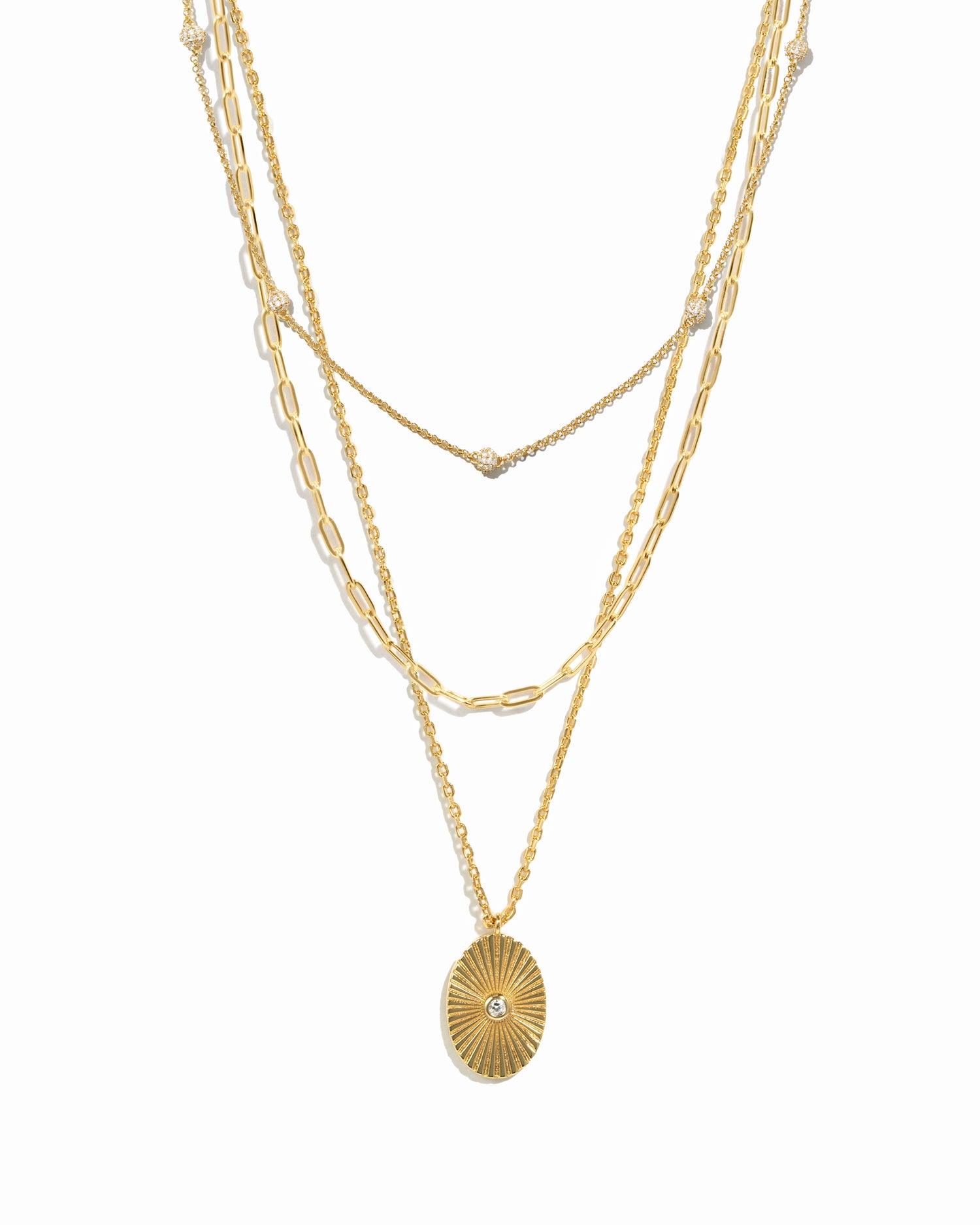 Gold layered chain necklaces with a paperclip chain and beaded necklace design, and a gold central pendant necklace on a white background