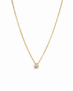 Gold pear pendant necklace on white background 