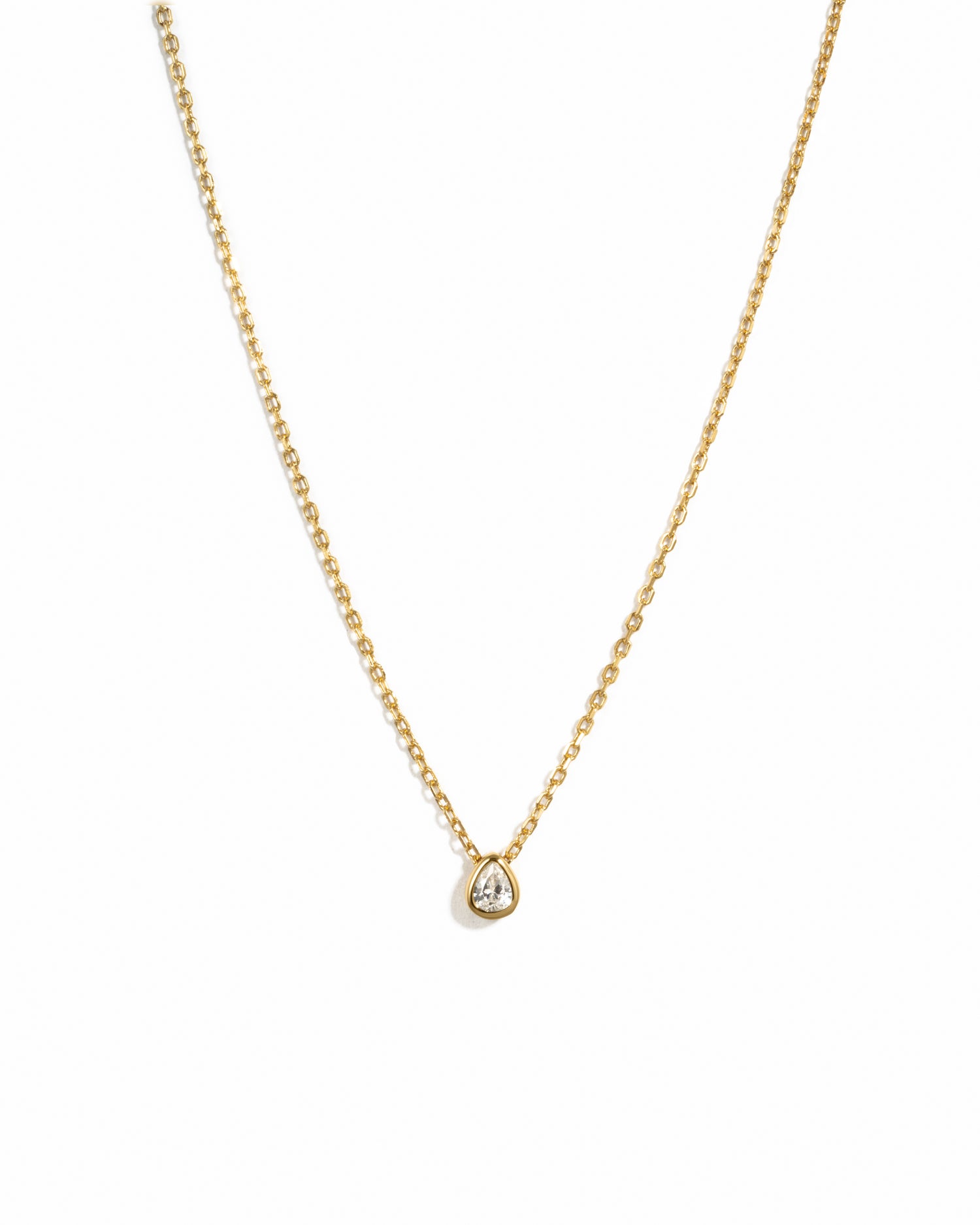 Gold pear pendant necklace on white background 