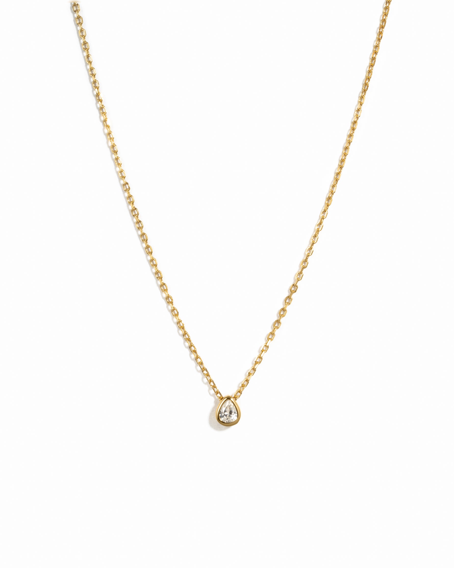 Gold pear pendant necklace on white background 