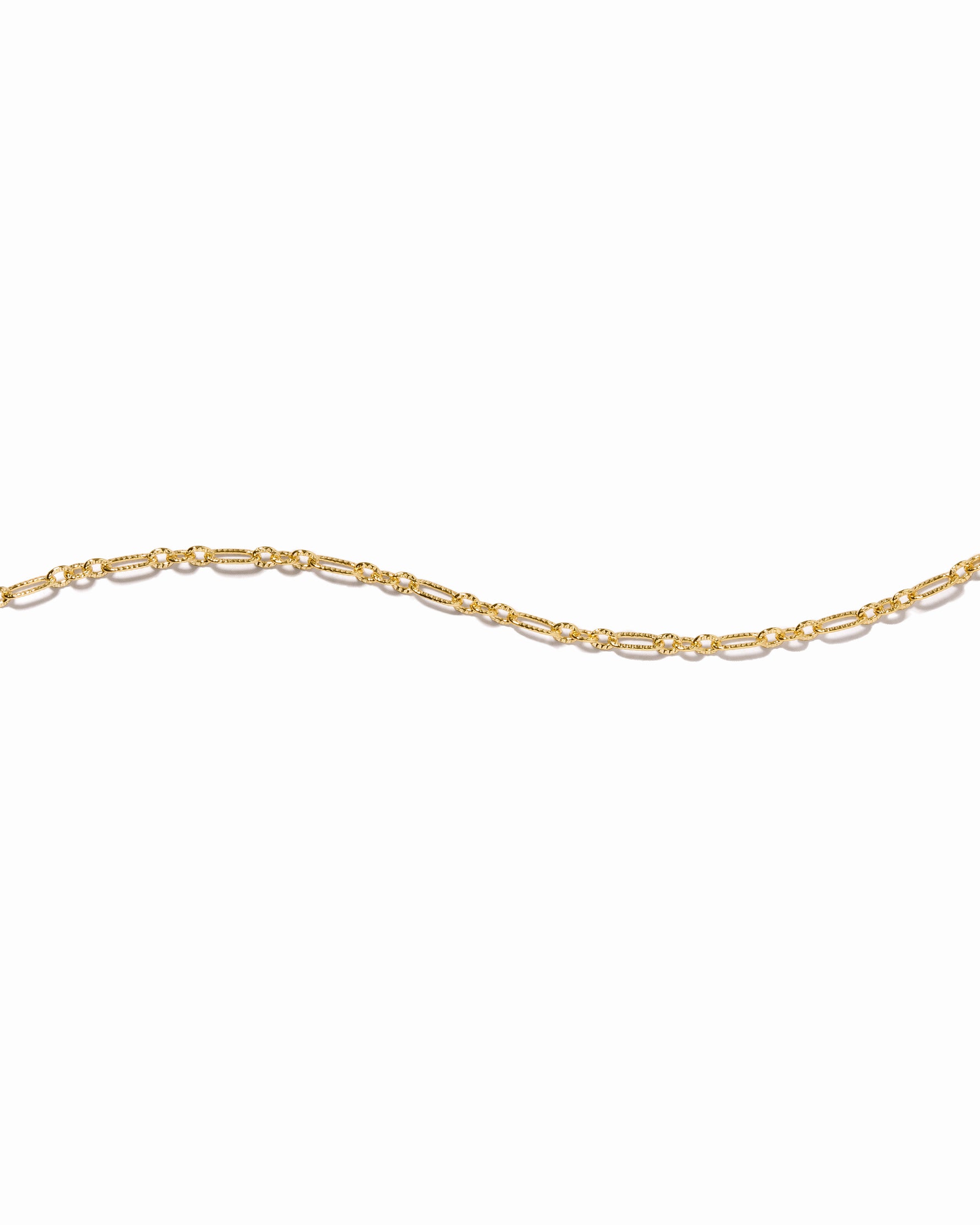 textured stackable gold bracelet on a white background