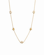 Gold plated charm necklace with small star charms on a white background 