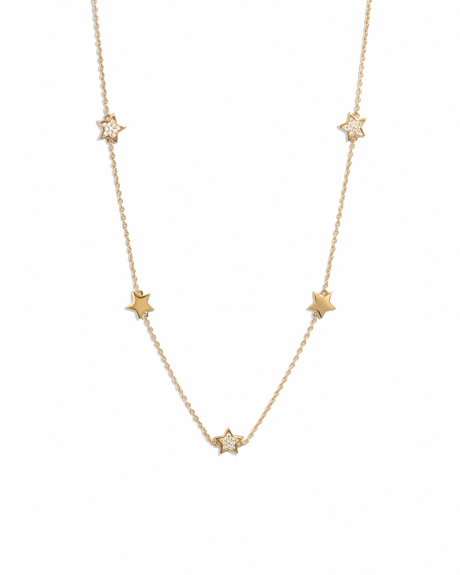 Gold plated charm necklace with small star charms on a white background 
