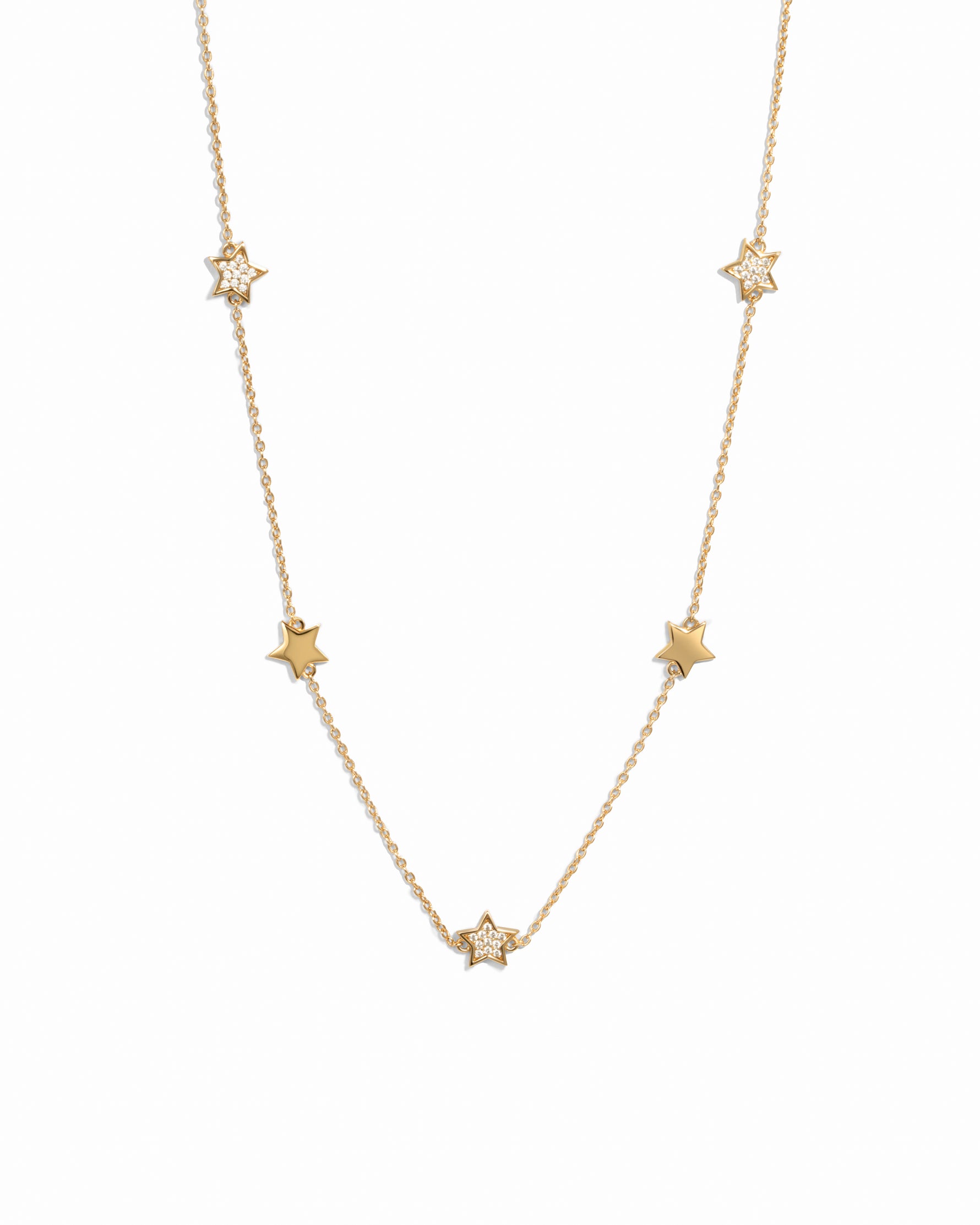 Gold plated charm necklace with small star charms on a white background 