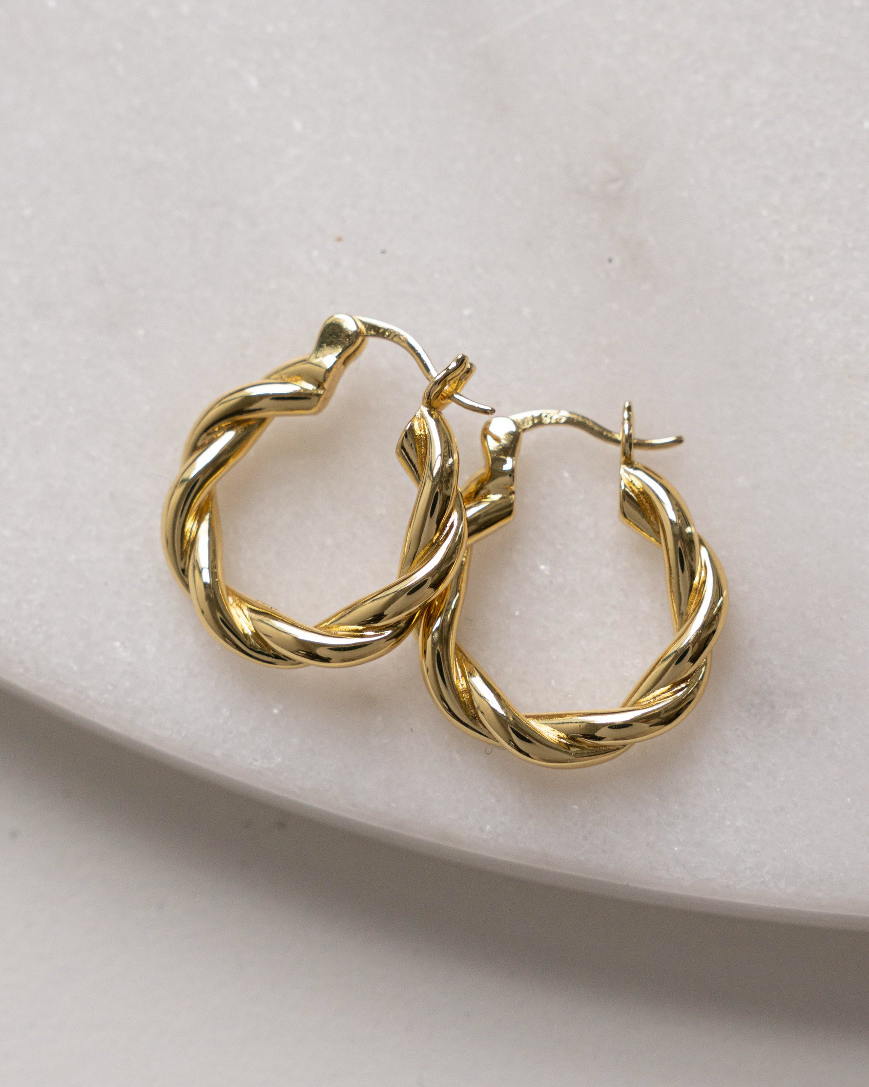 Gold chunky spiral hoop earrings.