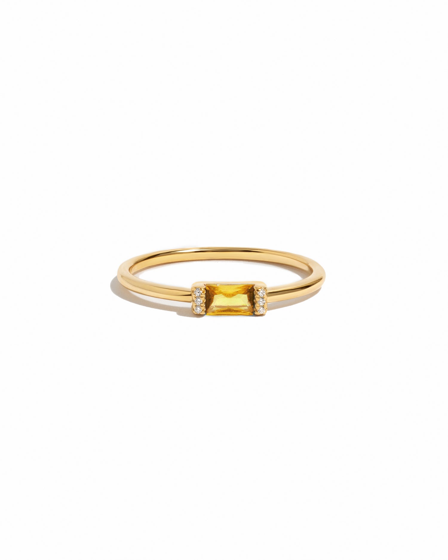 Gold citrine birthstone ring on a white background
