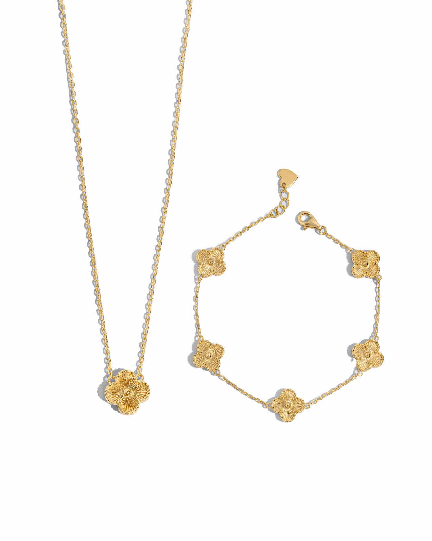 Gold pendant clover necklace and clover bracelet set on a white background