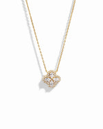 Close-up of four leaf clover pendant inspired by Van Cleef, highlighting intricate diamond details of pear shaped stones made of cubic zirconia.