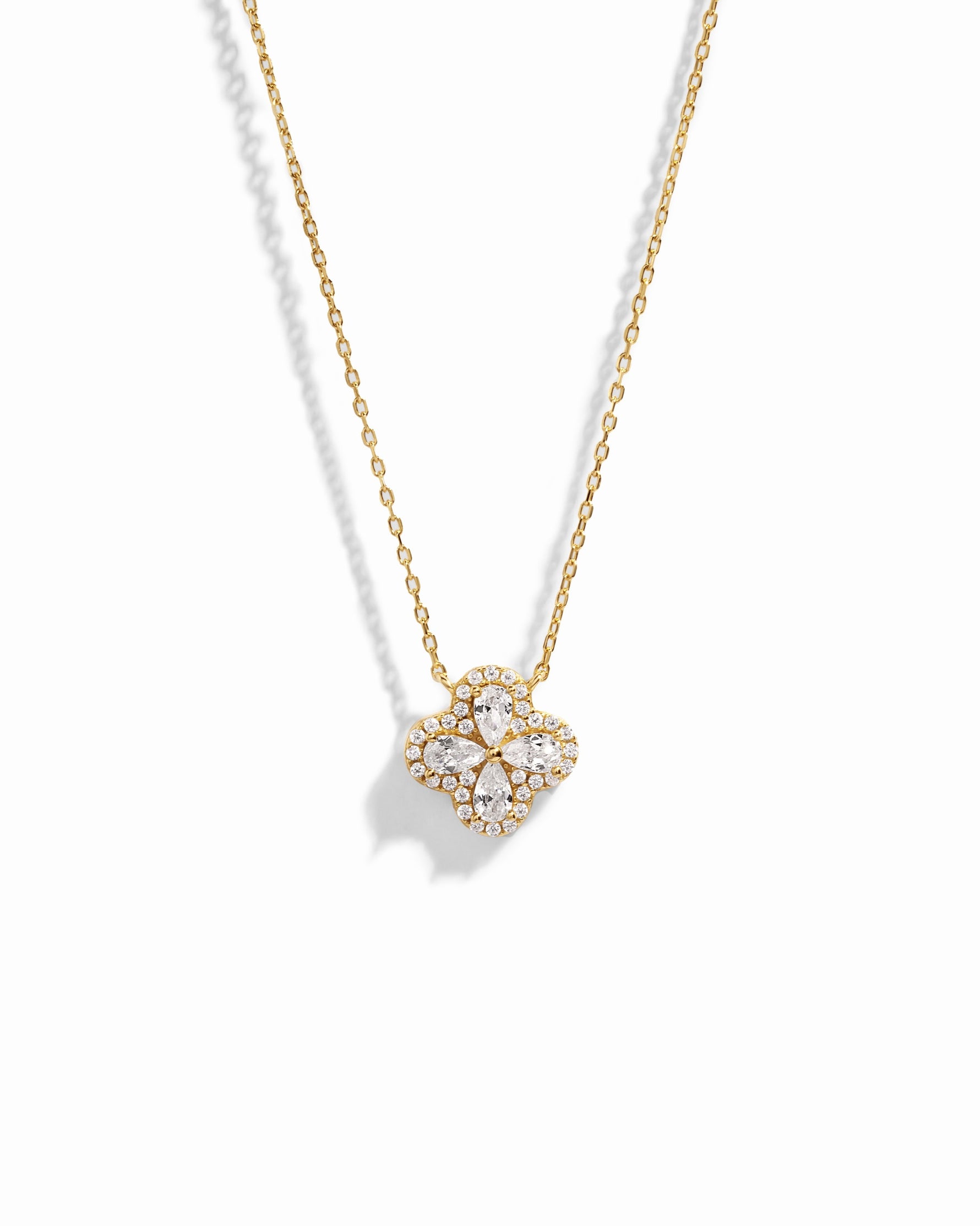 Close-up of four leaf clover pendant inspired by Van Cleef, highlighting intricate diamond details of pear shaped stones made of cubic zirconia.