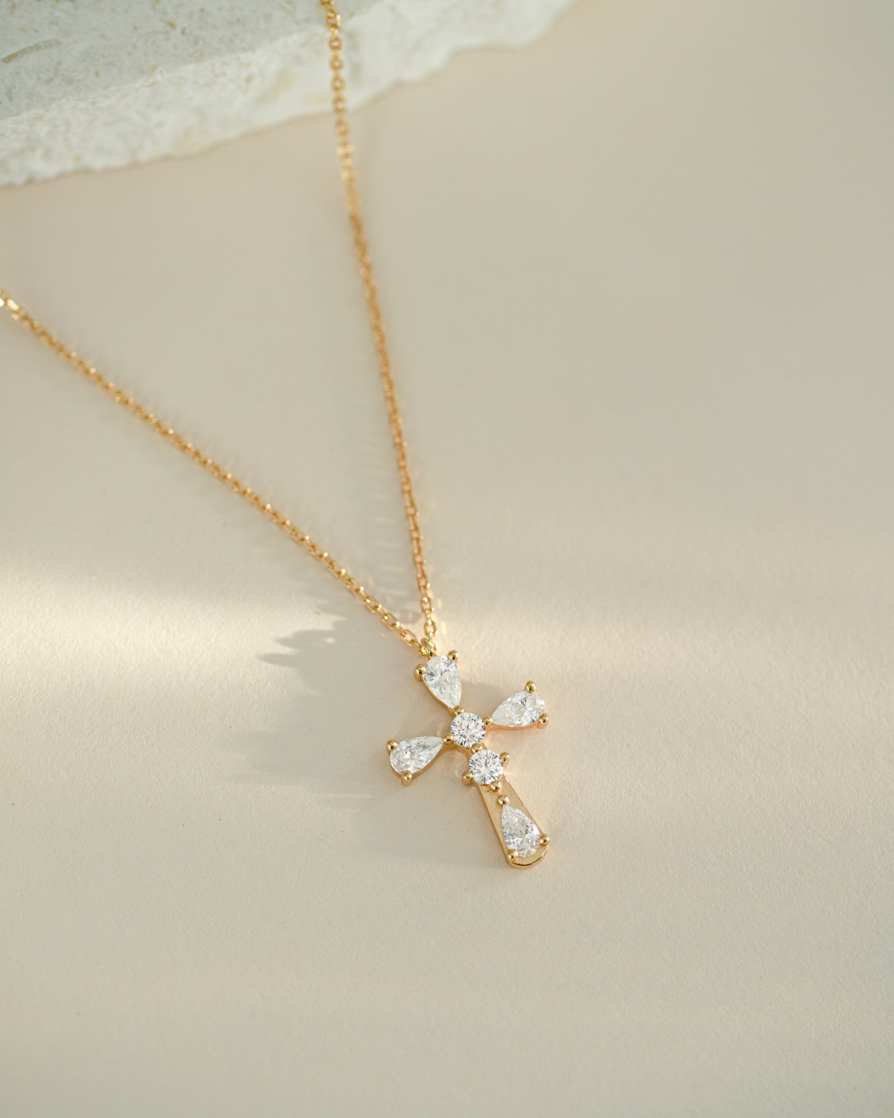 Gold gemstone necklace on beige background