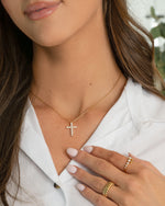 Gold chain layering necklace with a diamond pendant and gold stackable rings