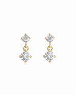 Gold diamond charm earrings on a white background