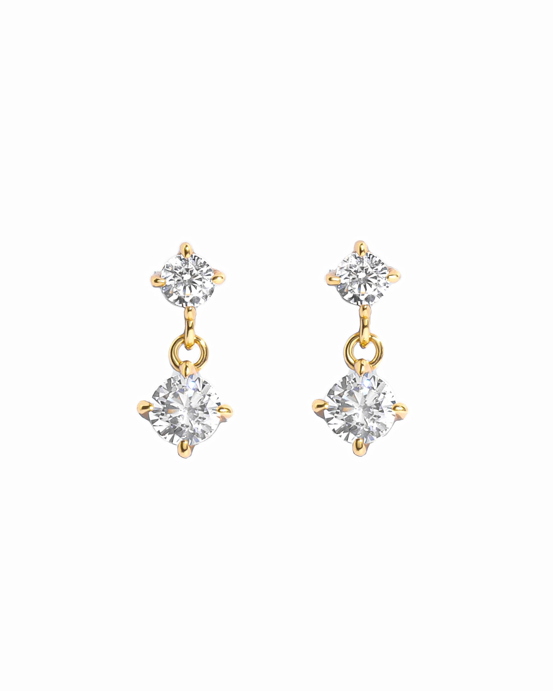 Gold diamond charm earrings on a white background