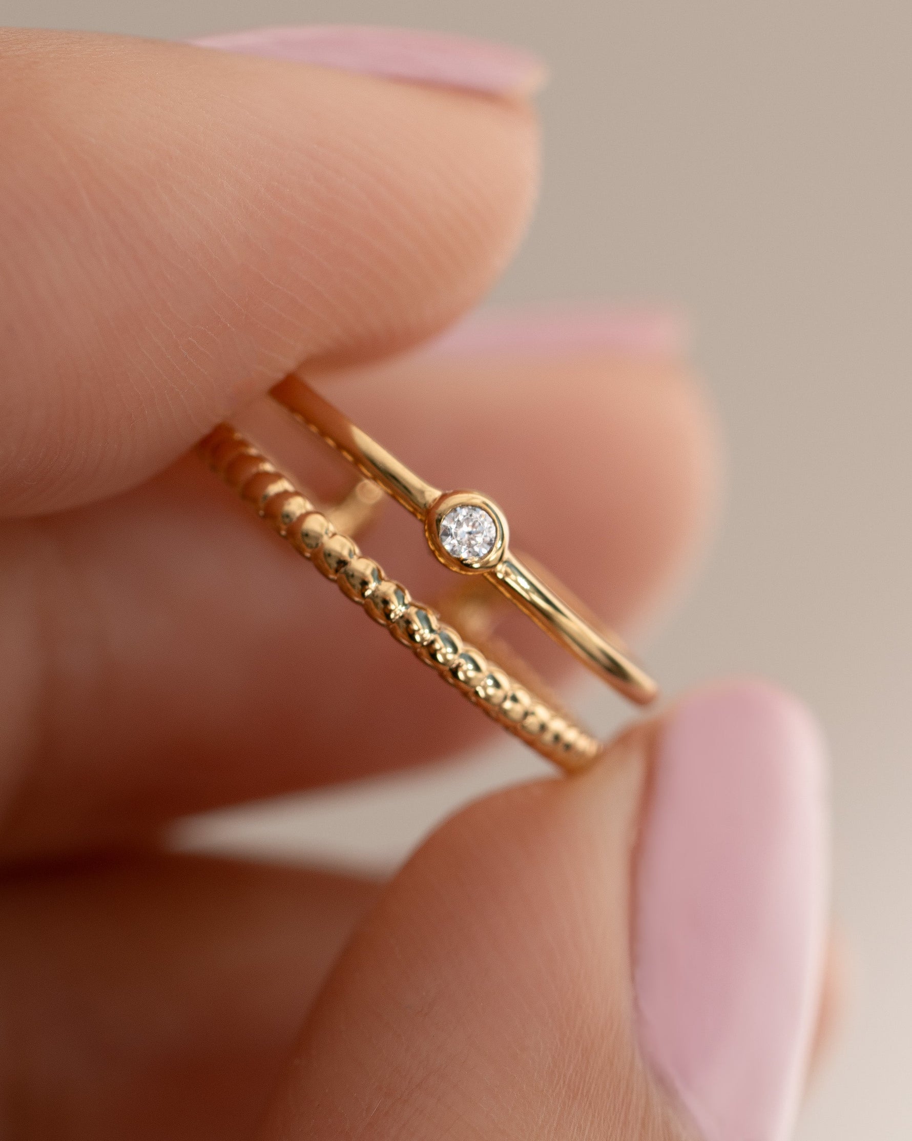 Gold boho toe ring being held between two fingers