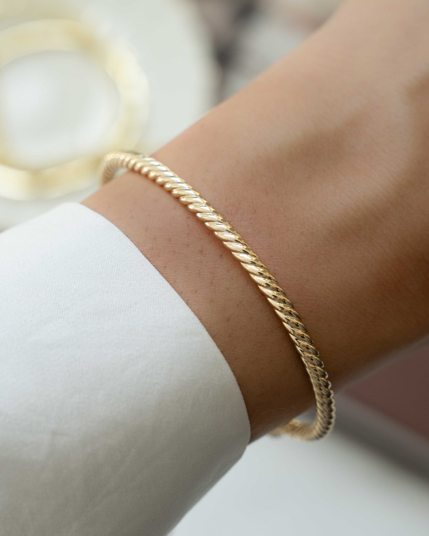 closeup image of gold twisted cuff bangle bracelet