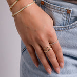 model wearing gold jewelry featuring minimalist diamond ring