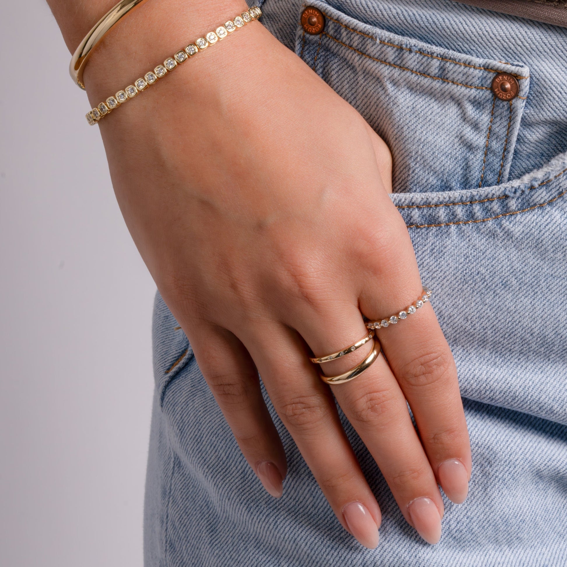 model wearing gold jewelry featuring minimalist diamond ring