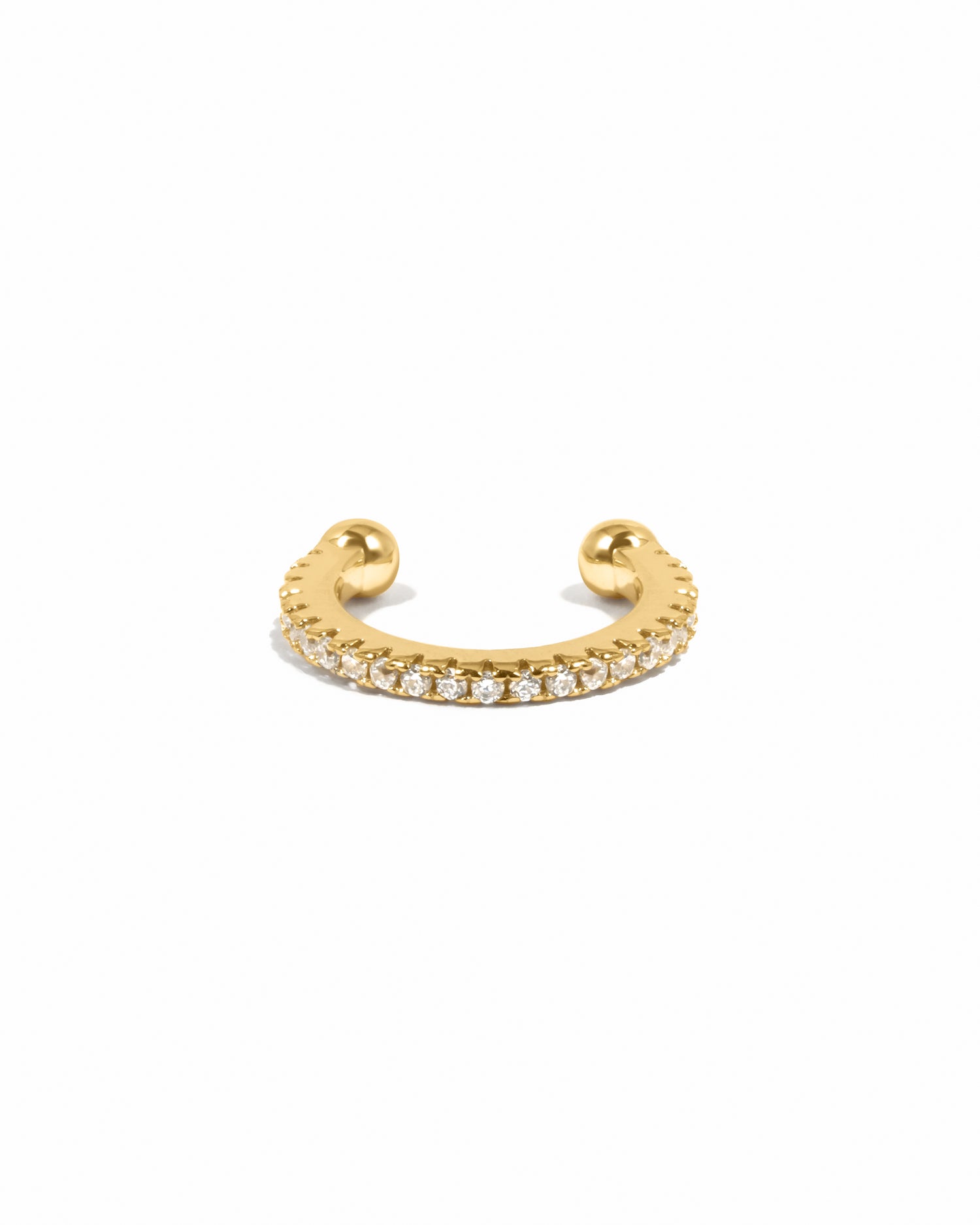 Gold ear cuff with cubic zirconia diamonds on a white background 