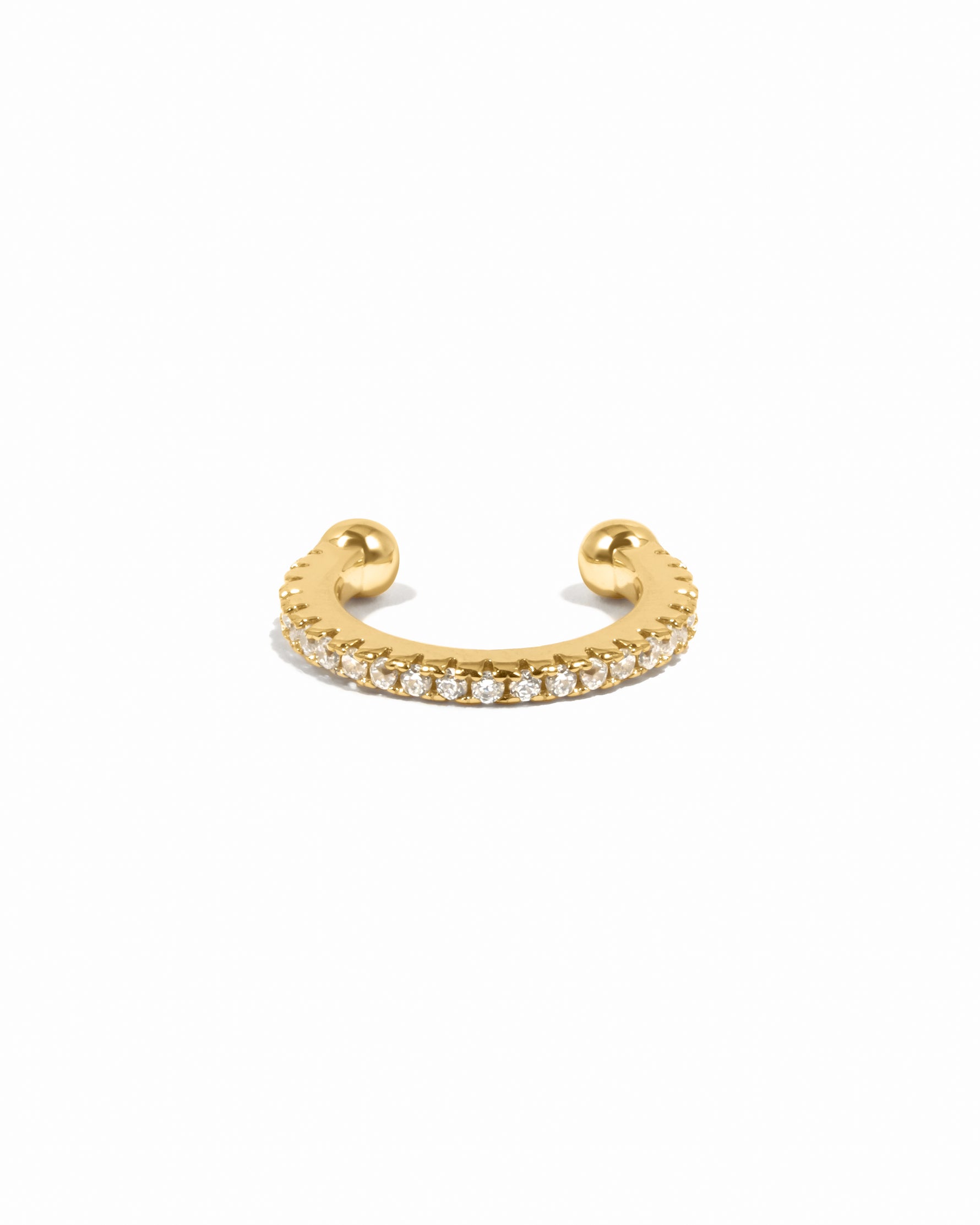 Gold ear cuff with cubic zirconia diamonds on a white background 