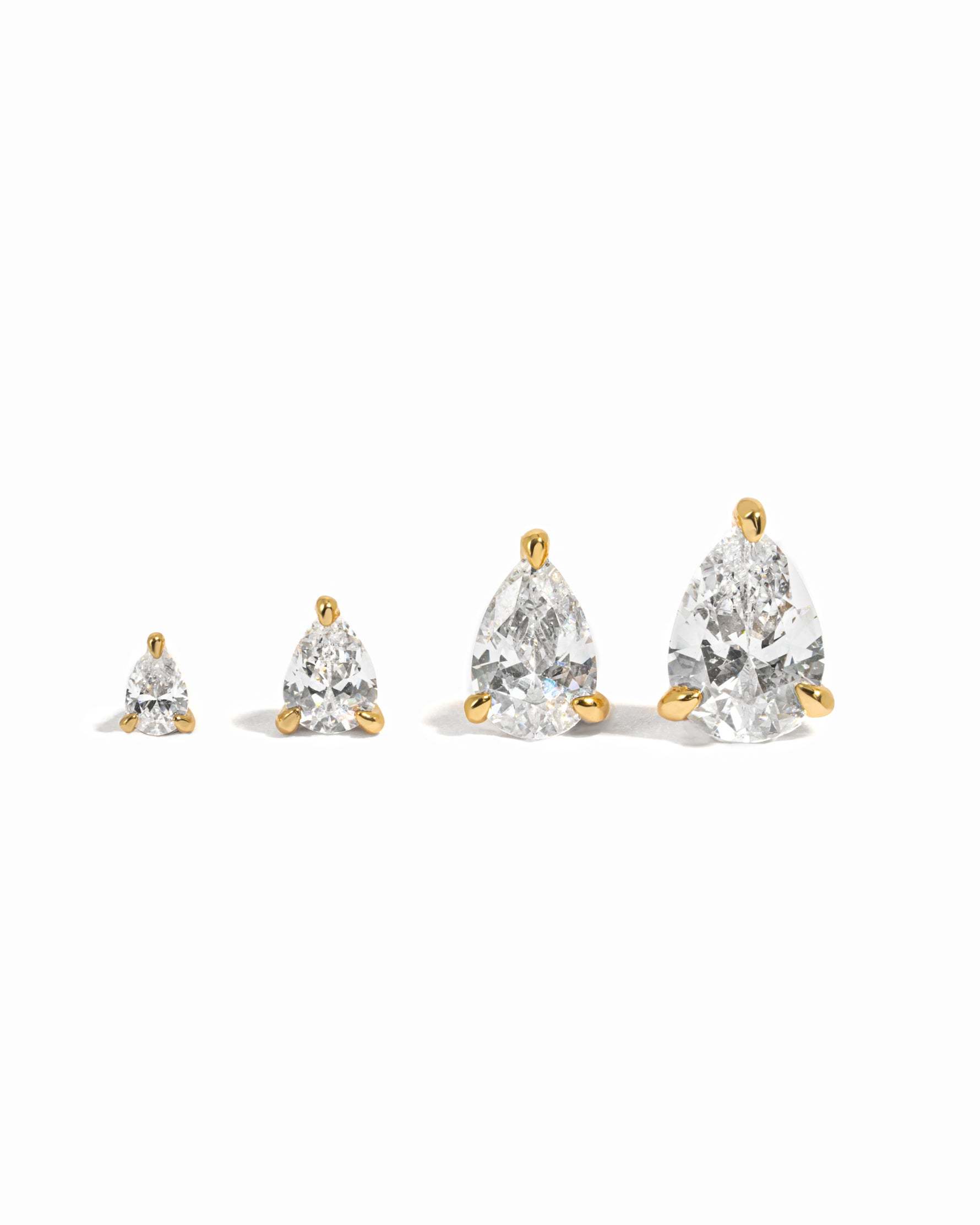 Pear cut gold stud earrings on a white background