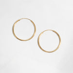 Closeup image of dainty gold hoop earrings