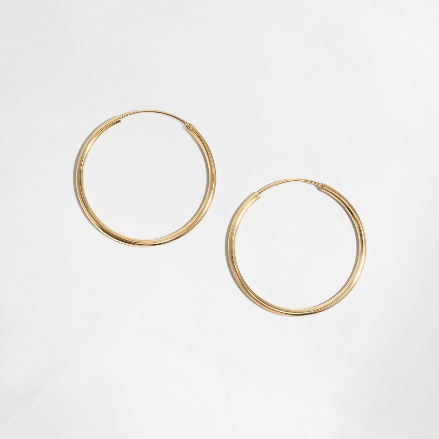 Closeup image of dainty gold hoop earrings