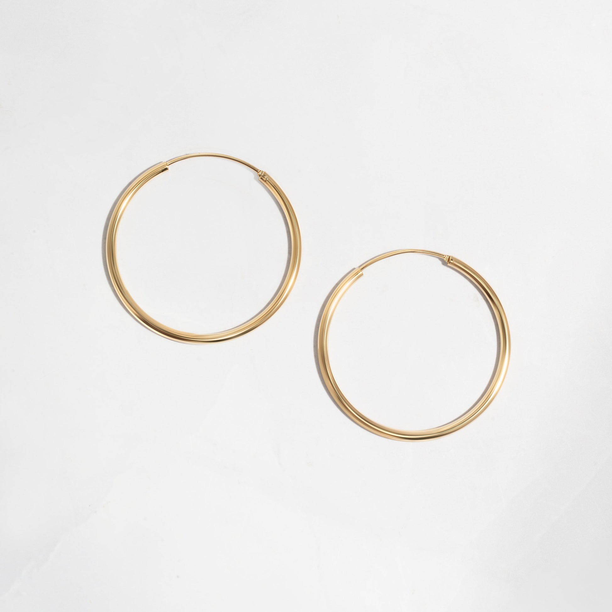 Closeup image of dainty gold hoop earrings