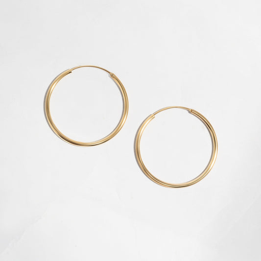 Closeup image of dainty gold hoop earrings