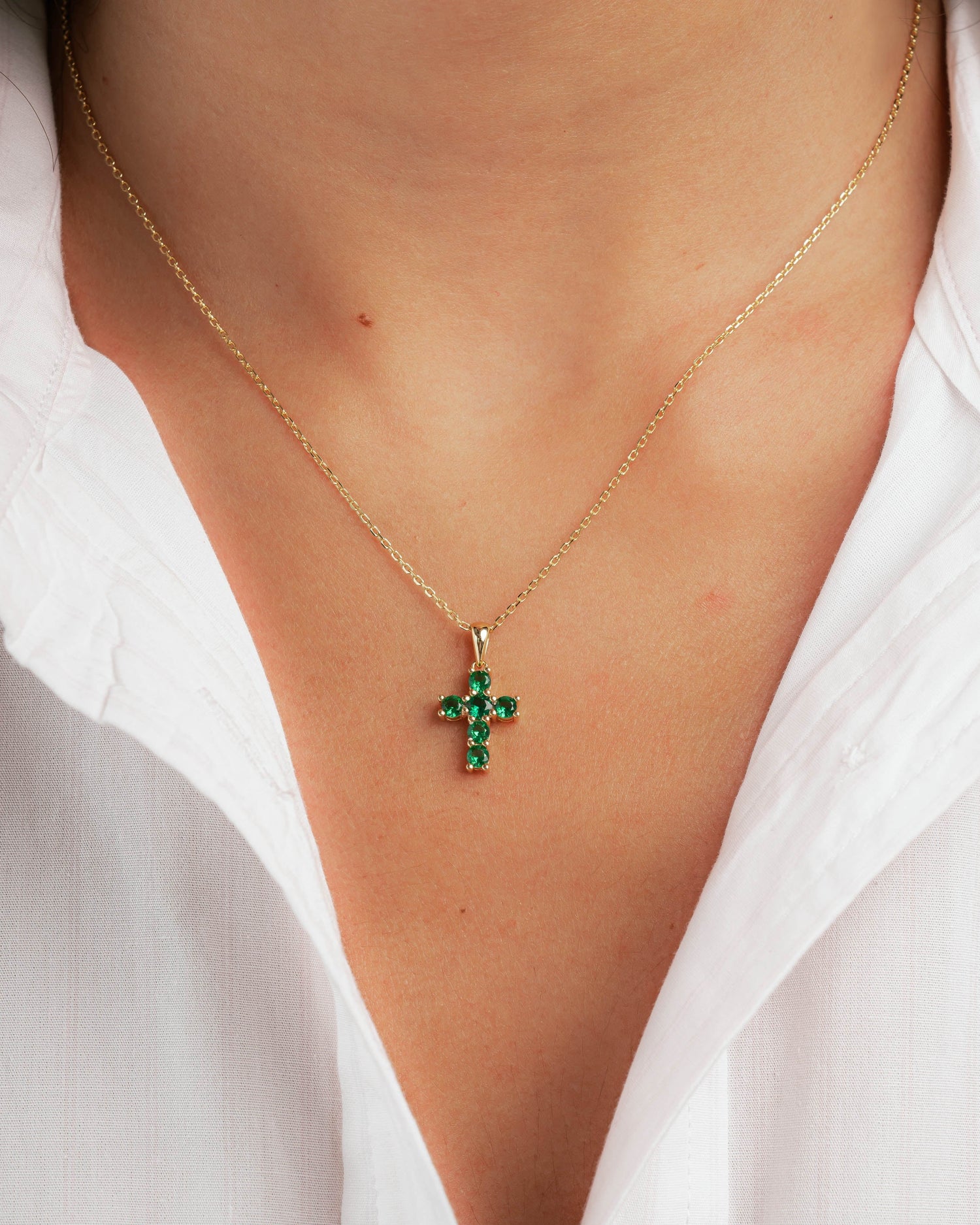 Gold chain necklace with a cross pendant on model