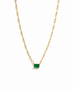 Gold necklace with a emerald pendant on a white background