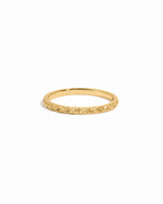 Thin gold ring on white background