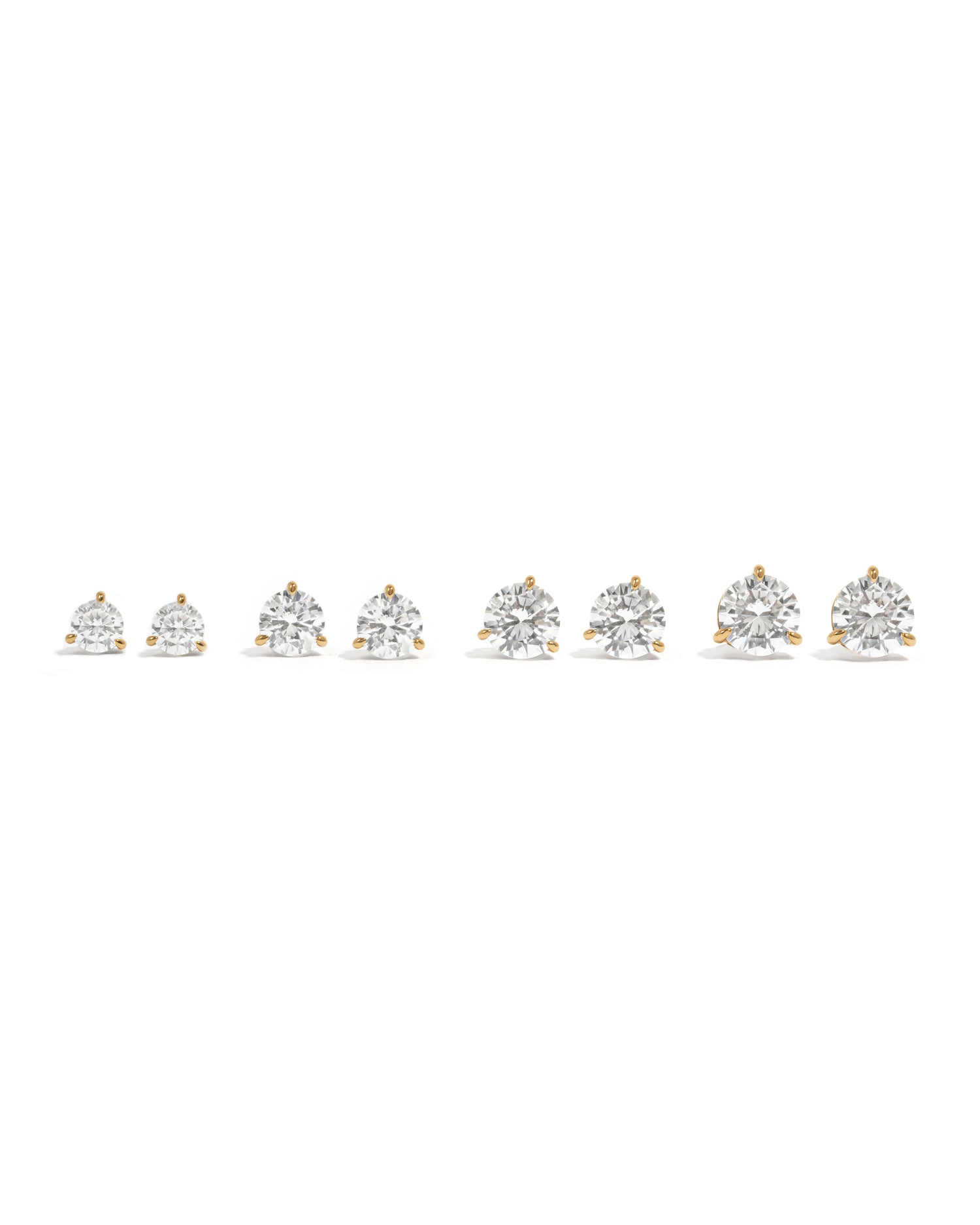 Gold round solitaire stud earrings on a white background