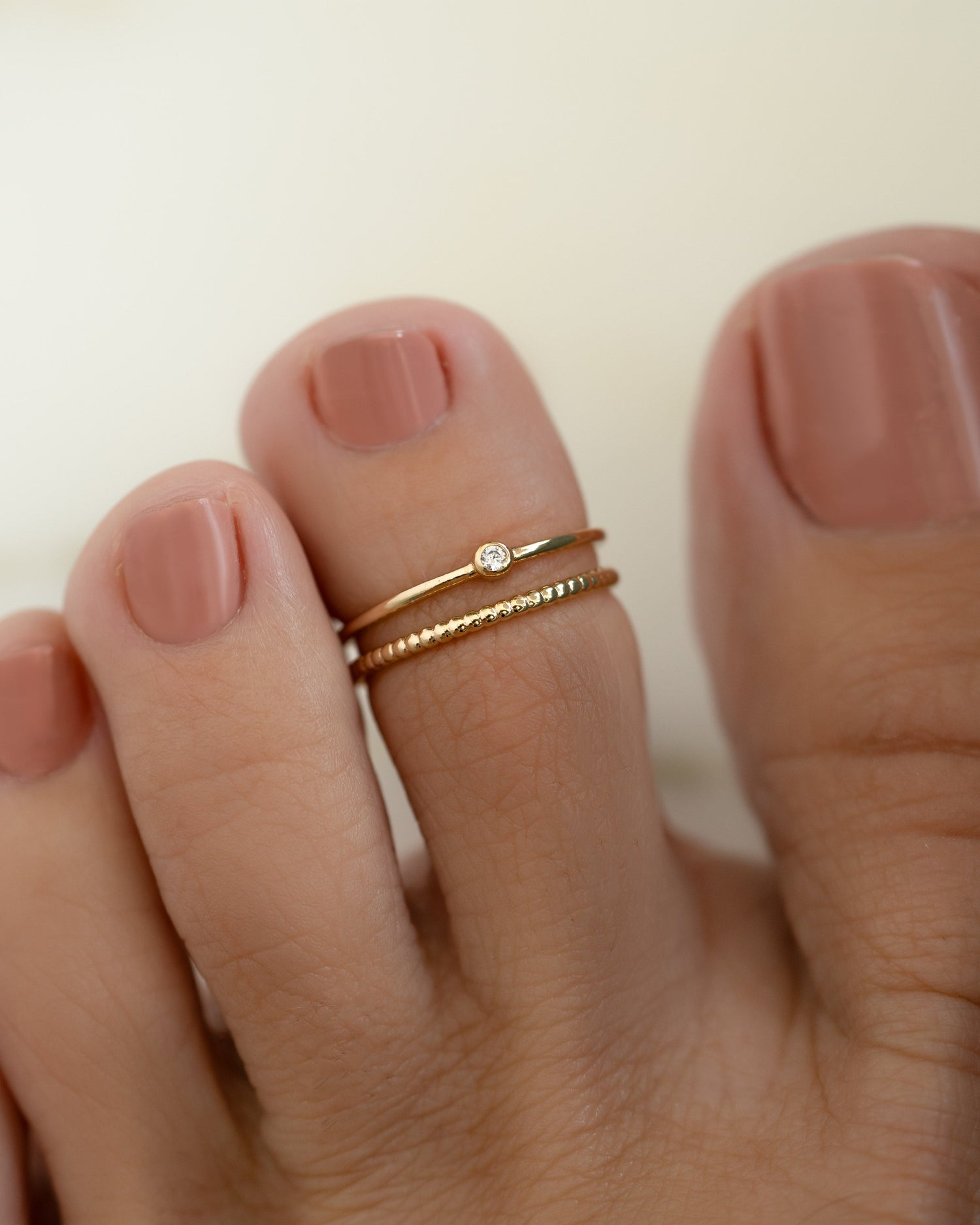 Gold minimalist toe ring on model