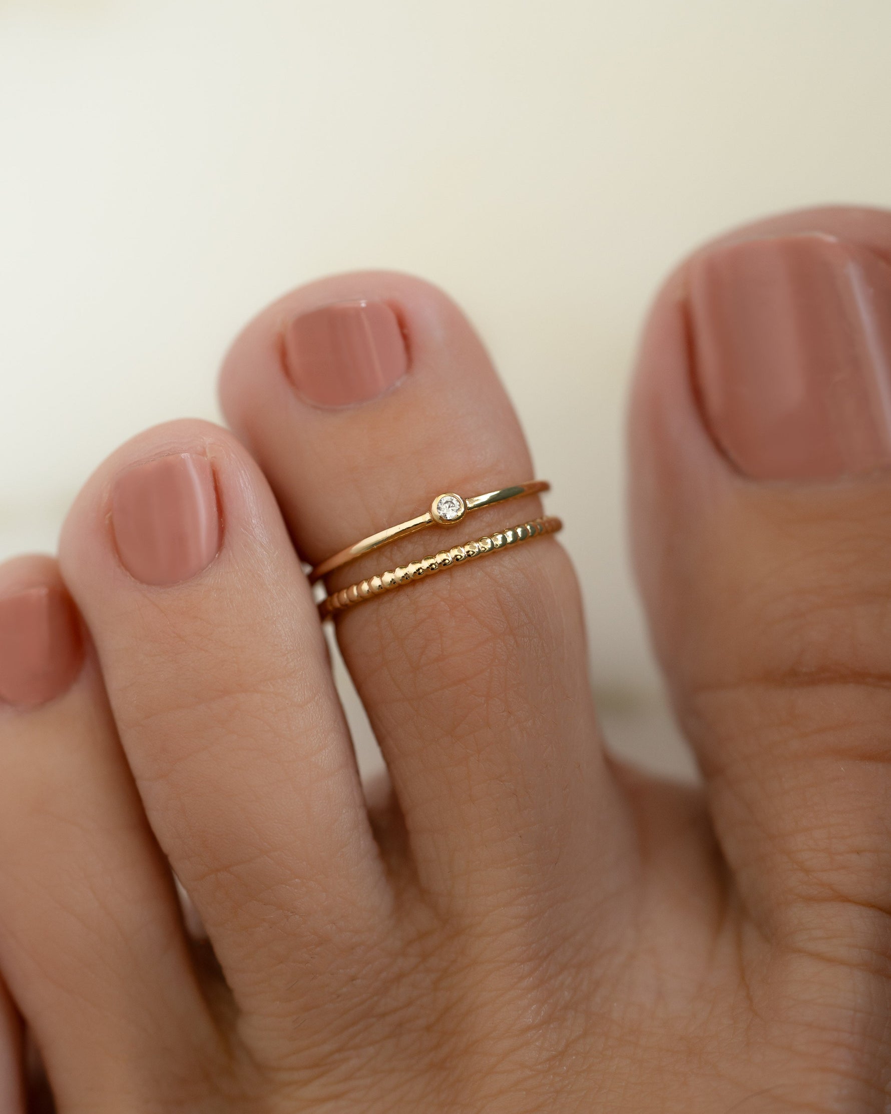 Gold minimalist toe ring on model