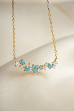 closeup image of gold chain gemstone necklace
