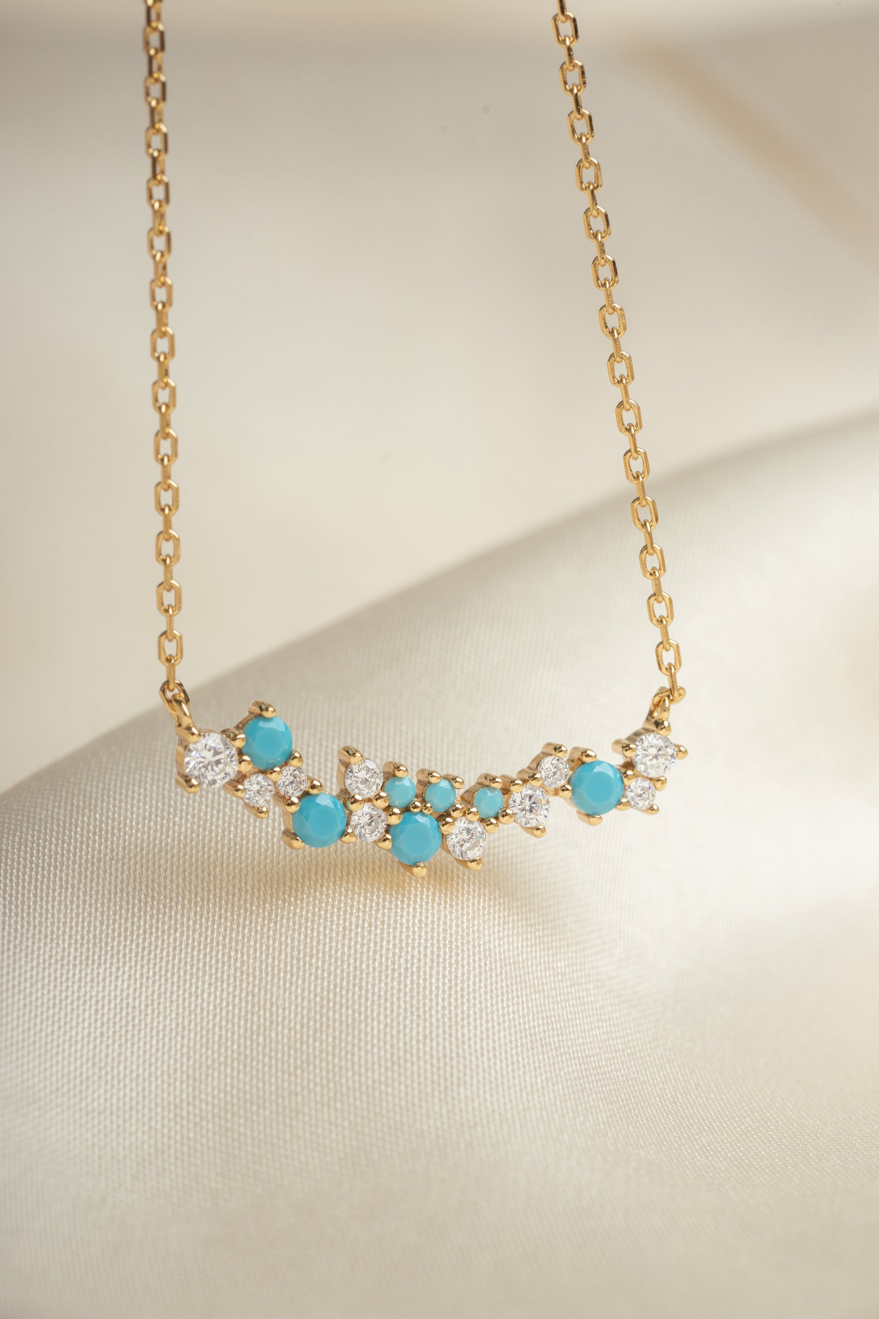 closeup image of gold chain gemstone necklace