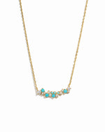 Gold necklace with turquoise stones on a white background