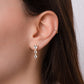 Model wearing elegant pear-shaped teardrop earrings in gold with sparkling cubic zirconia stones.