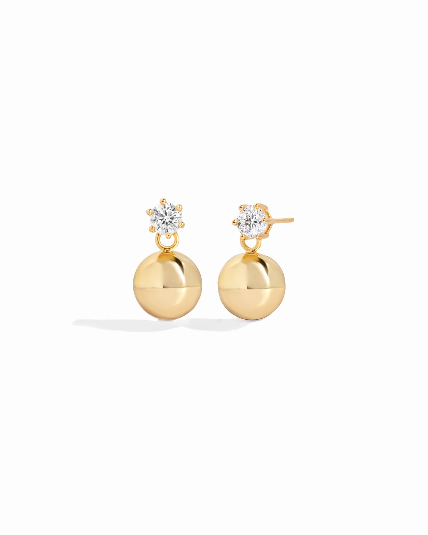 Close up of ball and diamond-crusted and gold earrings
