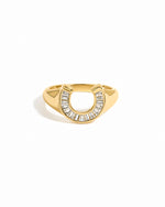 Gold horseshoe signet ring on a white background