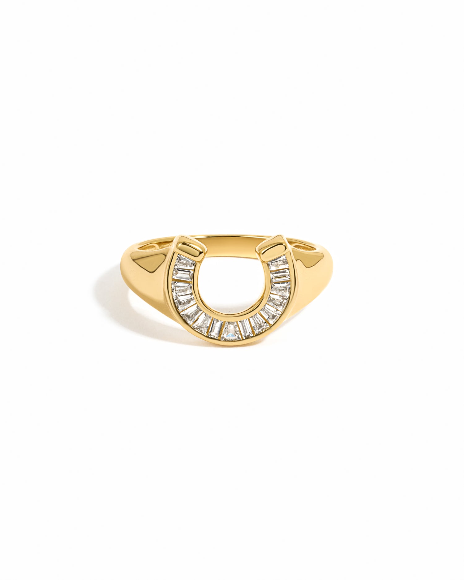 Gold horseshoe signet ring on a white background