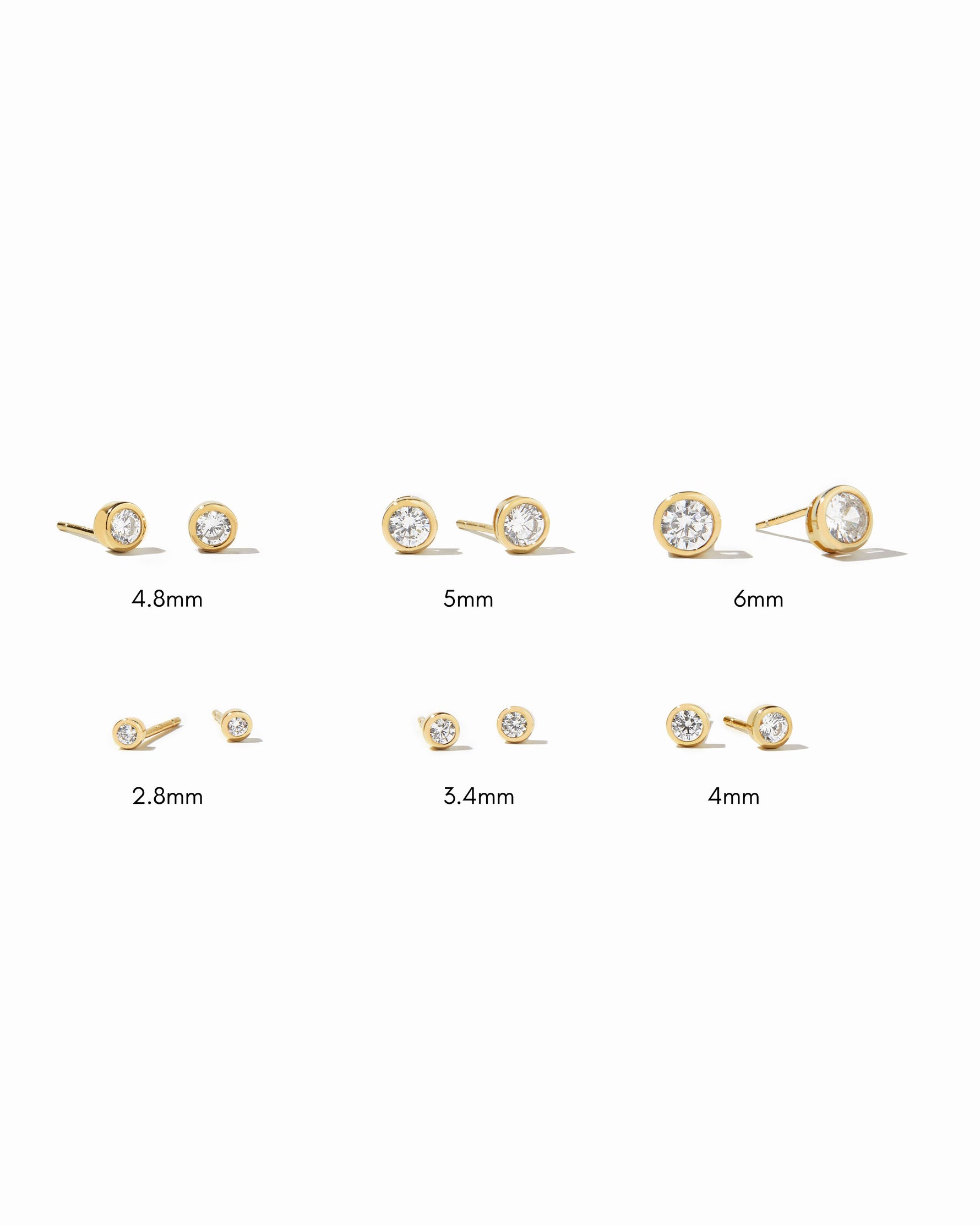 Set of gold bezel stud earrings with varying sizes on a white background