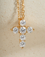 Gold chain dainty cross necklace on a beige background