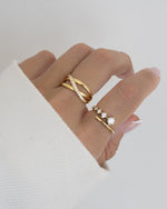 double band gold x ring on model and diamond bypass ring in 14k gold plating